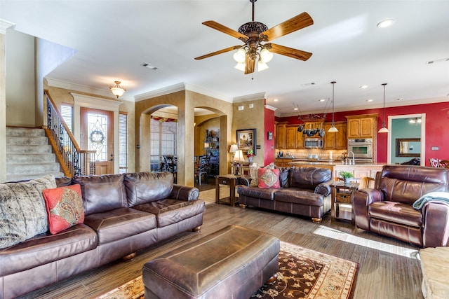 living room featuring a ceiling fan, visible vents, arched walkways, wood finished floors, and recessed lighting