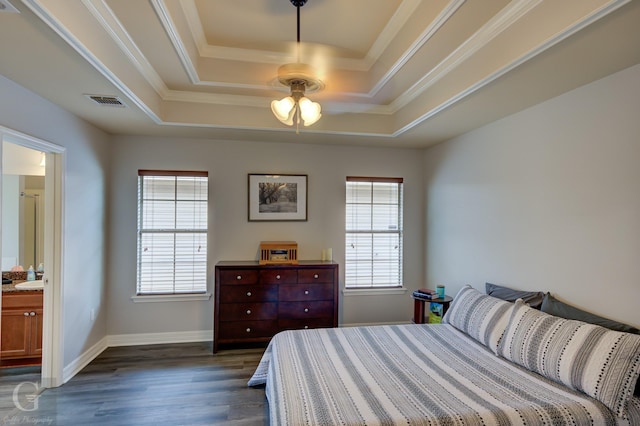 bedroom with dark wood-type flooring, ornamental molding, a tray ceiling, and multiple windows