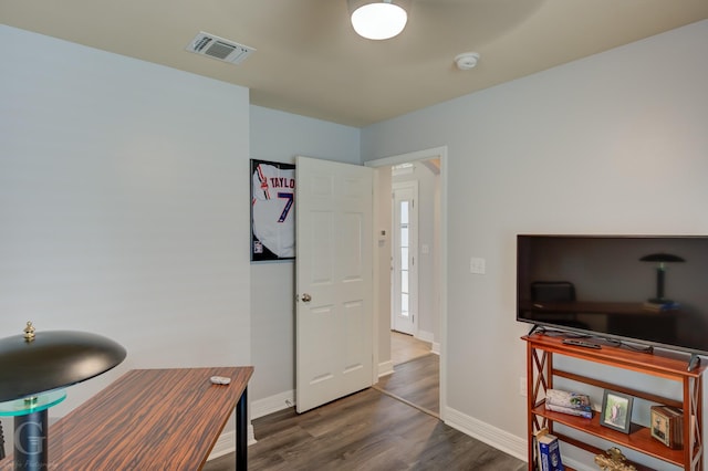 office area with baseboards, visible vents, and wood finished floors