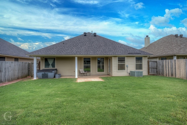rear view of house with a patio area, a fenced backyard, a hot tub, and roof with shingles