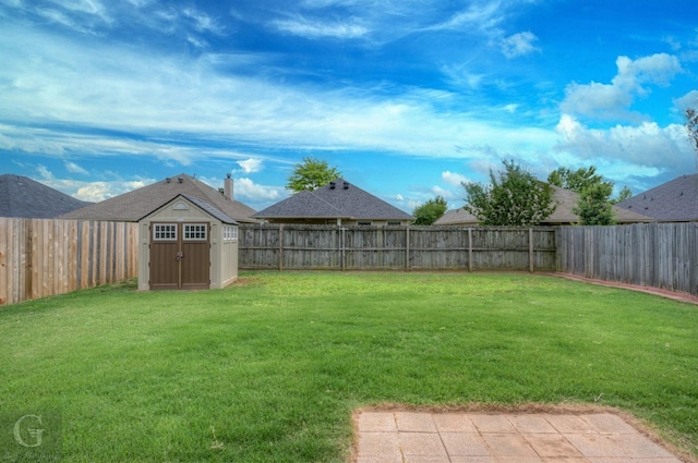 view of yard with a fenced backyard, an outbuilding, and a storage shed