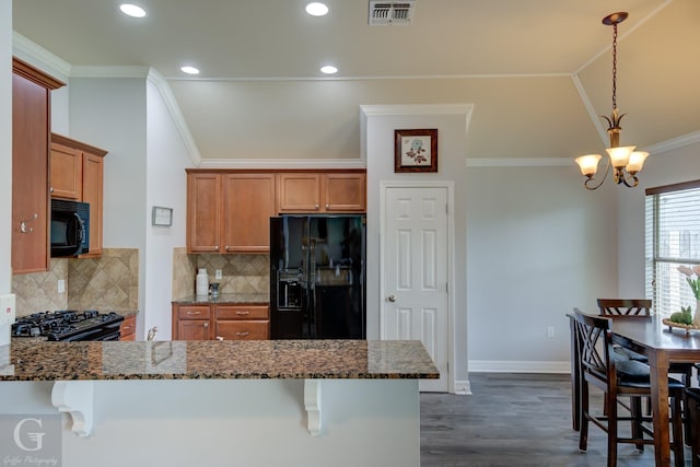 kitchen with visible vents, brown cabinets, black appliances, dark stone countertops, and dark wood-style floors