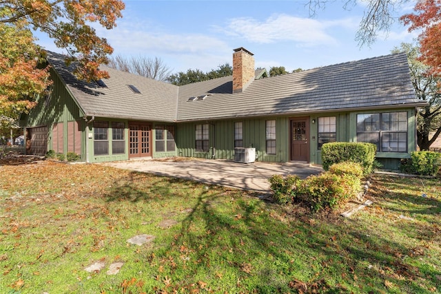 1215 Spring Lake Dr, Duncanville, TX 75137 - rear view of house with french doors, a chimney, board and batten siding, a patio area, and a yard