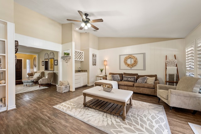 living area featuring dark wood-type flooring, ceiling fan, and high vaulted ceiling