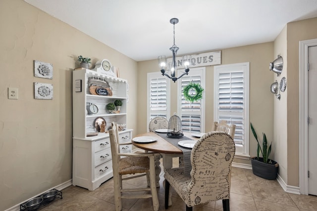 dining room with light tile patterned flooring, baseboards, and a notable chandelier