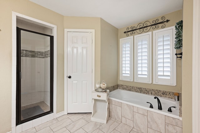 full bathroom featuring a garden tub, tile patterned flooring, and a shower stall