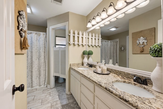 full bathroom featuring double vanity, visible vents, and a sink