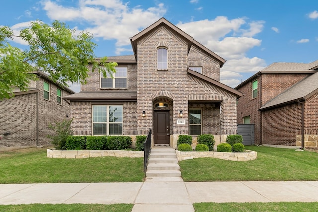 view of front of home featuring brick siding and a front lawn