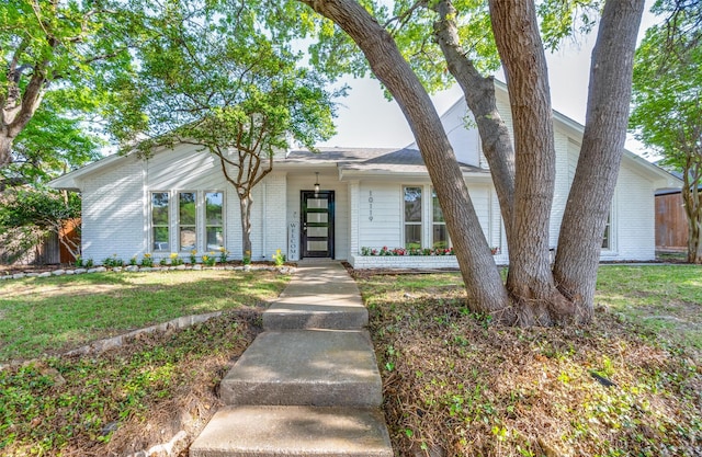 mid-century home with fence, a front lawn, and brick siding
