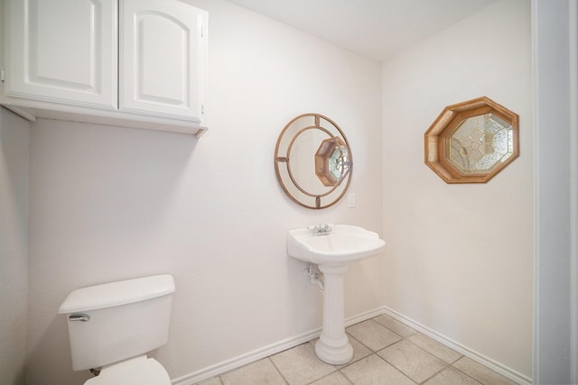 bathroom with baseboards, tile patterned flooring, and toilet