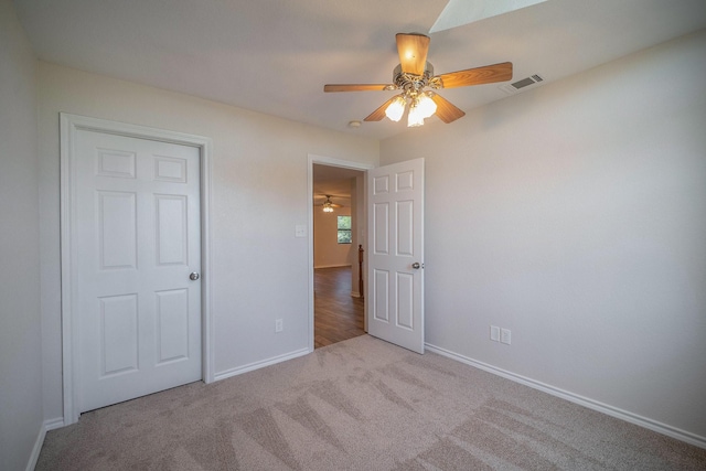 unfurnished bedroom featuring baseboards, a ceiling fan, carpet floors, and visible vents