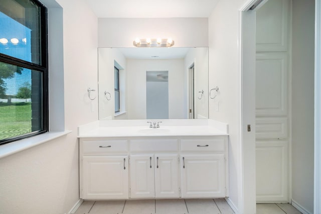 bathroom with vanity, baseboards, and tile patterned flooring