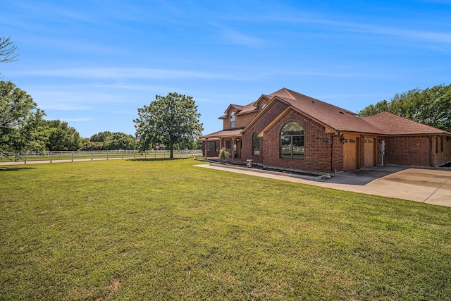 view of front facade with a garage, a front lawn, fence, brick siding, and driveway