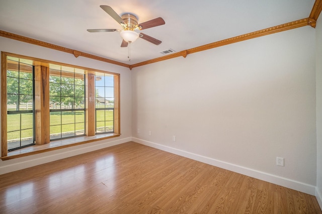 spare room with crown molding, baseboards, visible vents, and light wood-style floors
