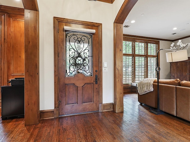 entrance foyer with arched walkways, dark wood finished floors, baseboards, ornamental molding, and recessed lighting