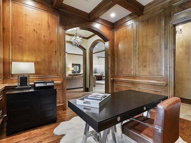 office space featuring ornamental molding, wood finished floors, beam ceiling, arched walkways, and coffered ceiling