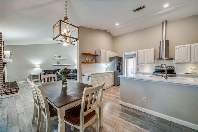 dining area with baseboards, light wood-type flooring, a chandelier, and visible vents