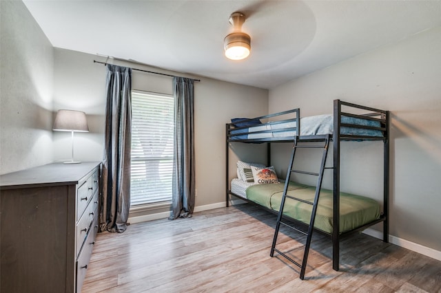 bedroom with baseboards, ceiling fan, and light wood finished floors