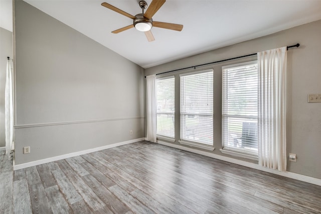 unfurnished room with wood finished floors, a ceiling fan, baseboards, and lofted ceiling