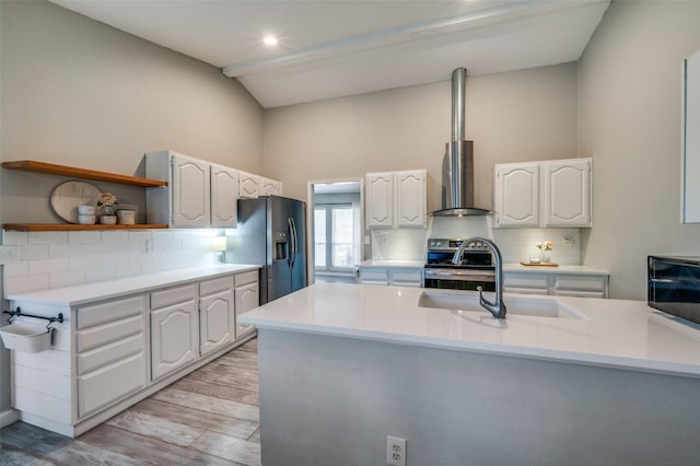 kitchen with open shelves, wall chimney range hood, tasteful backsplash, a sink, and stainless steel appliances