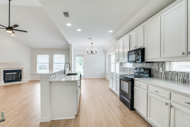 924 Bowie Dr, Lavon, TX 75166 - kitchen with black appliances, a sink, light wood-type flooring, decorative backsplash, and a chandelier