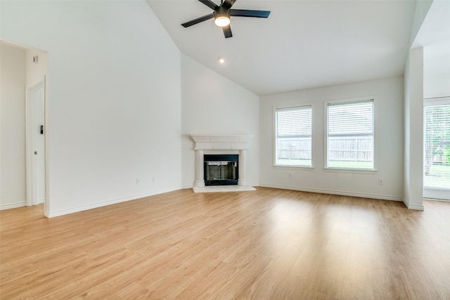 924 Bowie Dr, Lavon, TX 75166 - unfurnished living room with ceiling fan, a glass covered fireplace, light wood-style floors, high vaulted ceiling, and baseboards