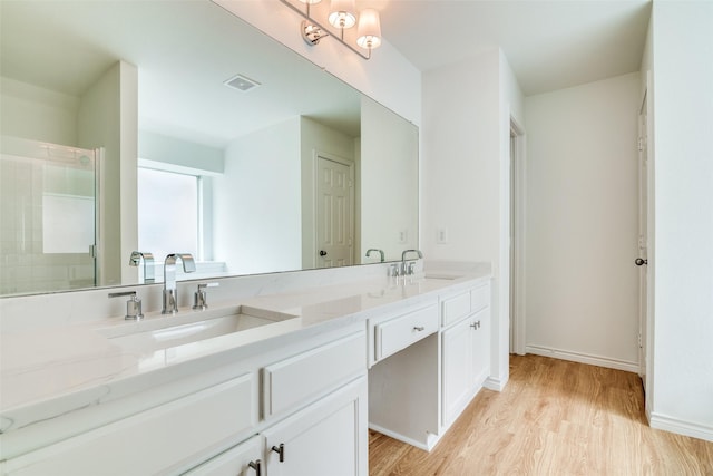 924 Bowie Dr, Lavon, TX 75166 - bathroom with wood finished floors, double vanity, a shower, and baseboards