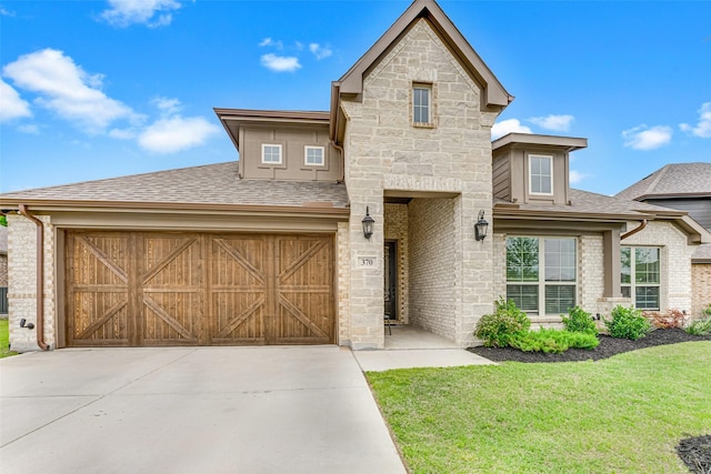 view of front facade with roof with shingles, stone siding, a garage, a front yard, and concrete driveway