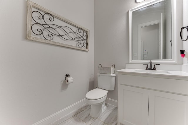 bathroom featuring vanity, baseboards, and toilet