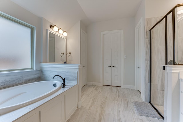 bathroom featuring a shower stall, a bath, and marble finish floor