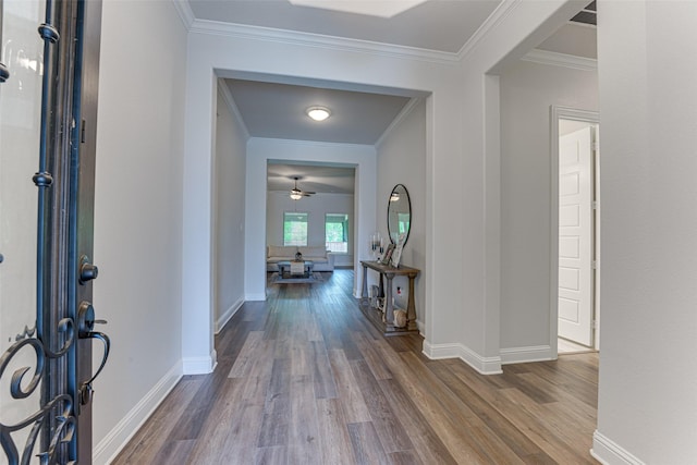 entryway featuring crown molding, baseboards, a ceiling fan, and wood finished floors