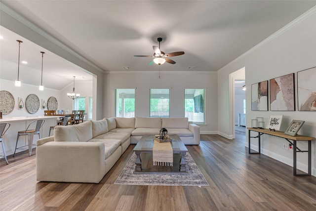 living area featuring crown molding, baseboards, ceiling fan with notable chandelier, and wood finished floors