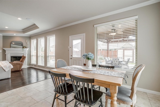 dining area with ornamental molding, light tile patterned flooring, baseboards, recessed lighting, and a fireplace with raised hearth