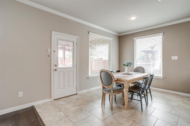 dining space with crown molding, baseboards, and a healthy amount of sunlight