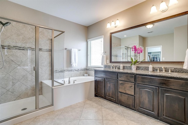 bathroom featuring a sink, double vanity, a shower stall, and a garden tub