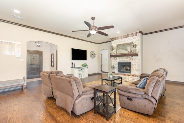 living room with a ceiling fan, visible vents, crown molding, wood finished floors, and arched walkways