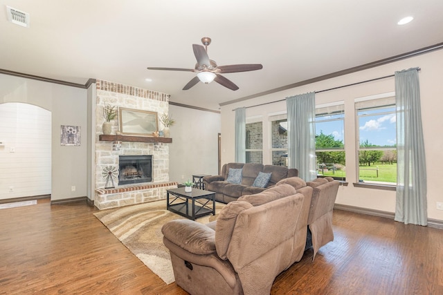 living room with crown molding, visible vents, baseboards, and a ceiling fan