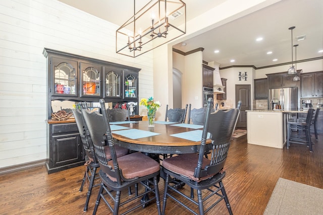 dining area featuring an inviting chandelier, crown molding, visible vents, and dark wood-style flooring