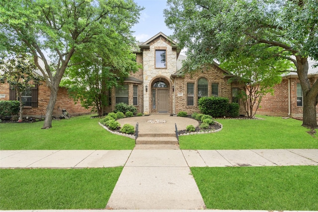 view of front facade with stone siding, brick siding, and a front yard