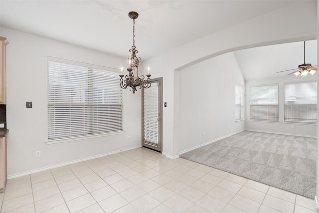 spare room featuring arched walkways, baseboards, ceiling fan with notable chandelier, lofted ceiling, and light carpet