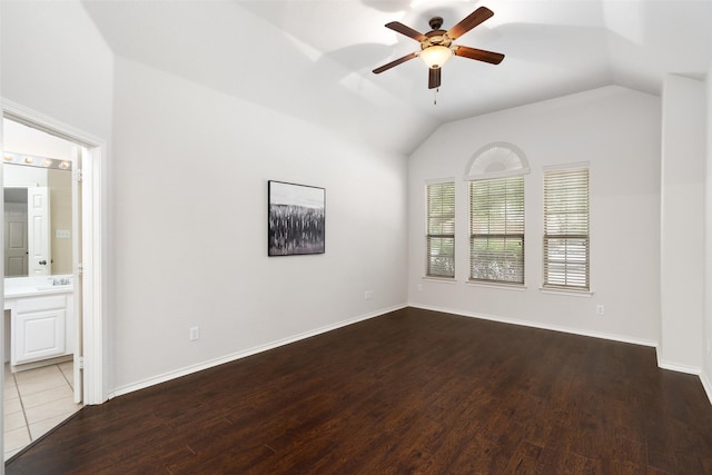 empty room featuring a ceiling fan, baseboards, wood finished floors, and lofted ceiling