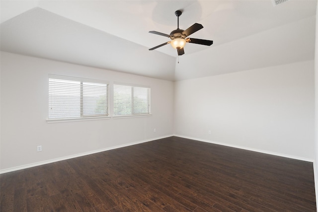 empty room featuring baseboards, a ceiling fan, vaulted ceiling, and dark wood-style floors