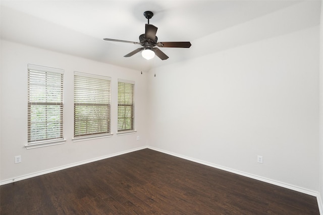 unfurnished room with baseboards and dark wood finished floors