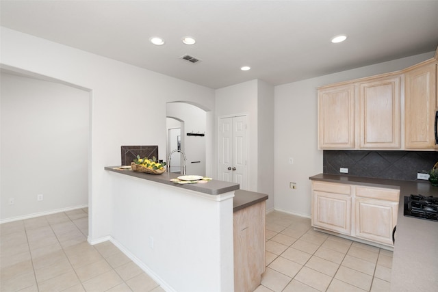 kitchen featuring light brown cabinets, arched walkways, recessed lighting, light tile patterned floors, and visible vents