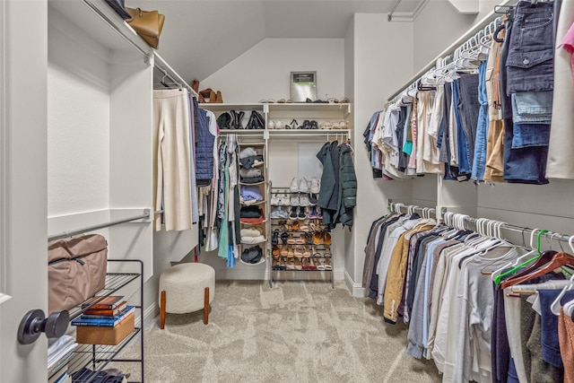 walk in closet with carpet floors and lofted ceiling