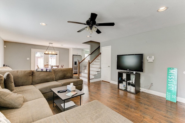 living area with stairs, baseboards, ceiling fan with notable chandelier, recessed lighting, and dark wood-type flooring