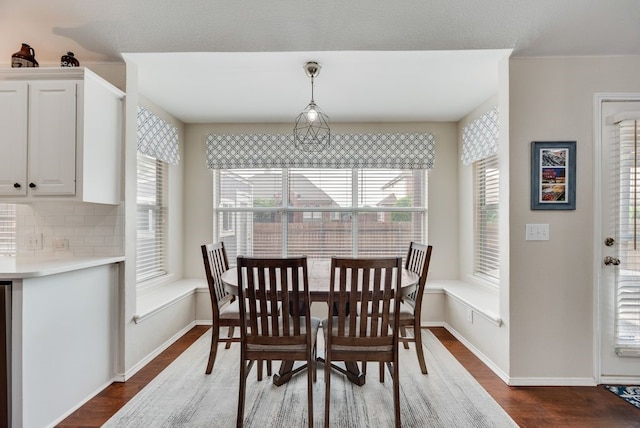 dining area featuring baseboards and dark wood-type flooring