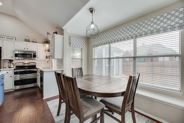dining space featuring vaulted ceiling and dark wood-type flooring