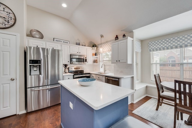 kitchen with a sink, appliances with stainless steel finishes, vaulted ceiling, and a healthy amount of sunlight