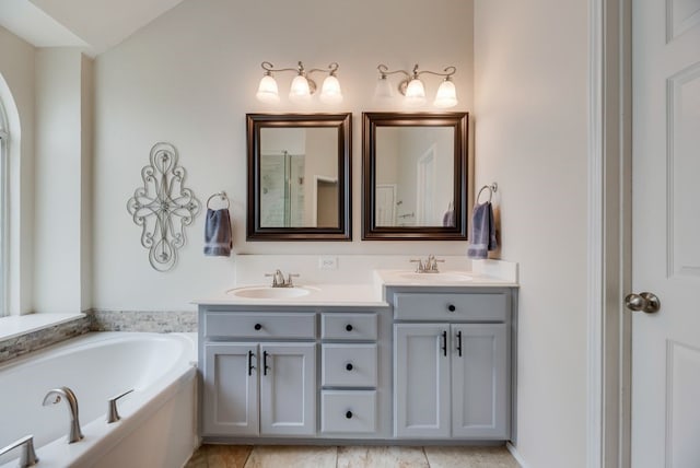 full bathroom with a sink, a garden tub, and double vanity